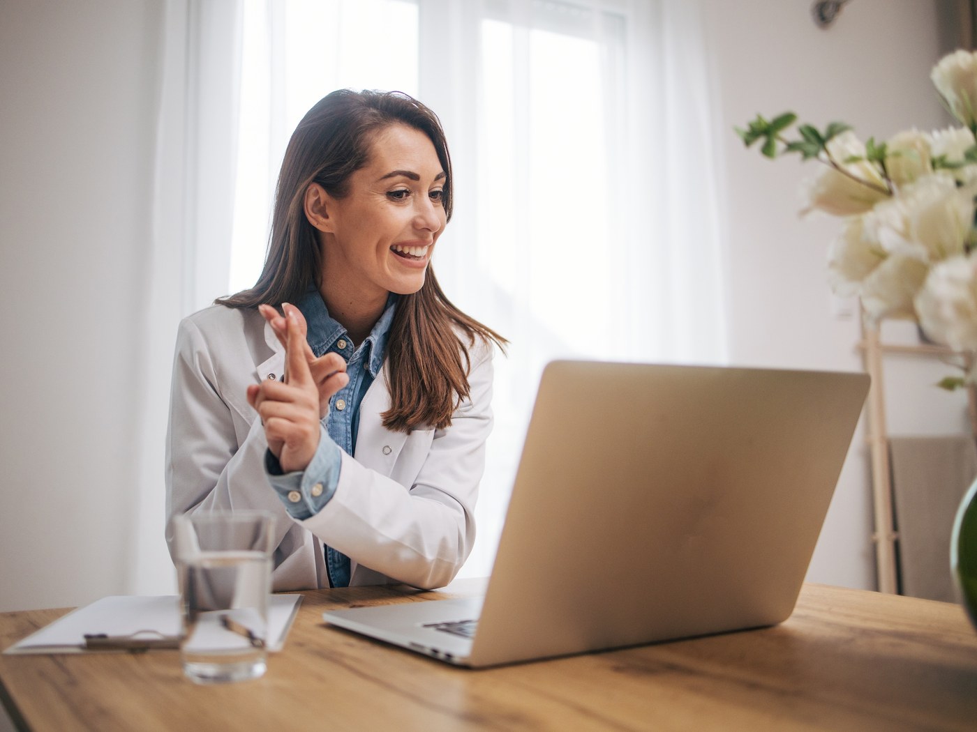 A Dermatologist consulting with a patient by secure video from her consulting room.